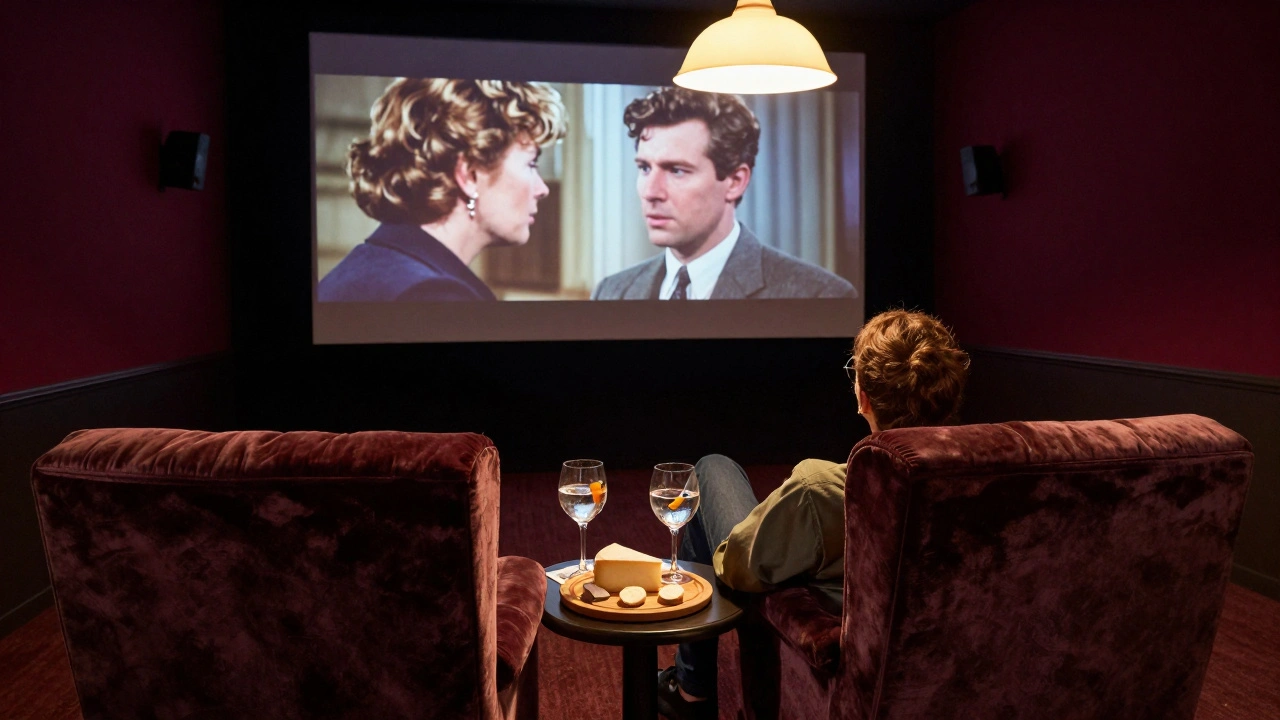 A couple cuddled in a velvet armchair in a private cinema, watching a film with a cheese board and drinks beside them.